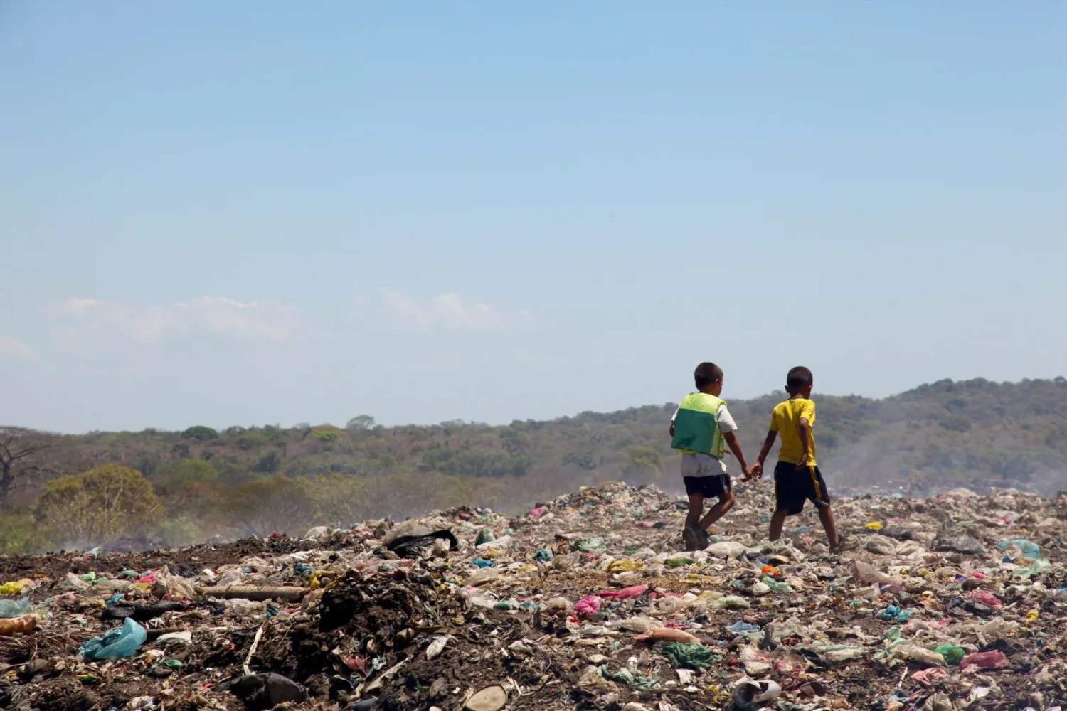 Children standing in a landfill.
