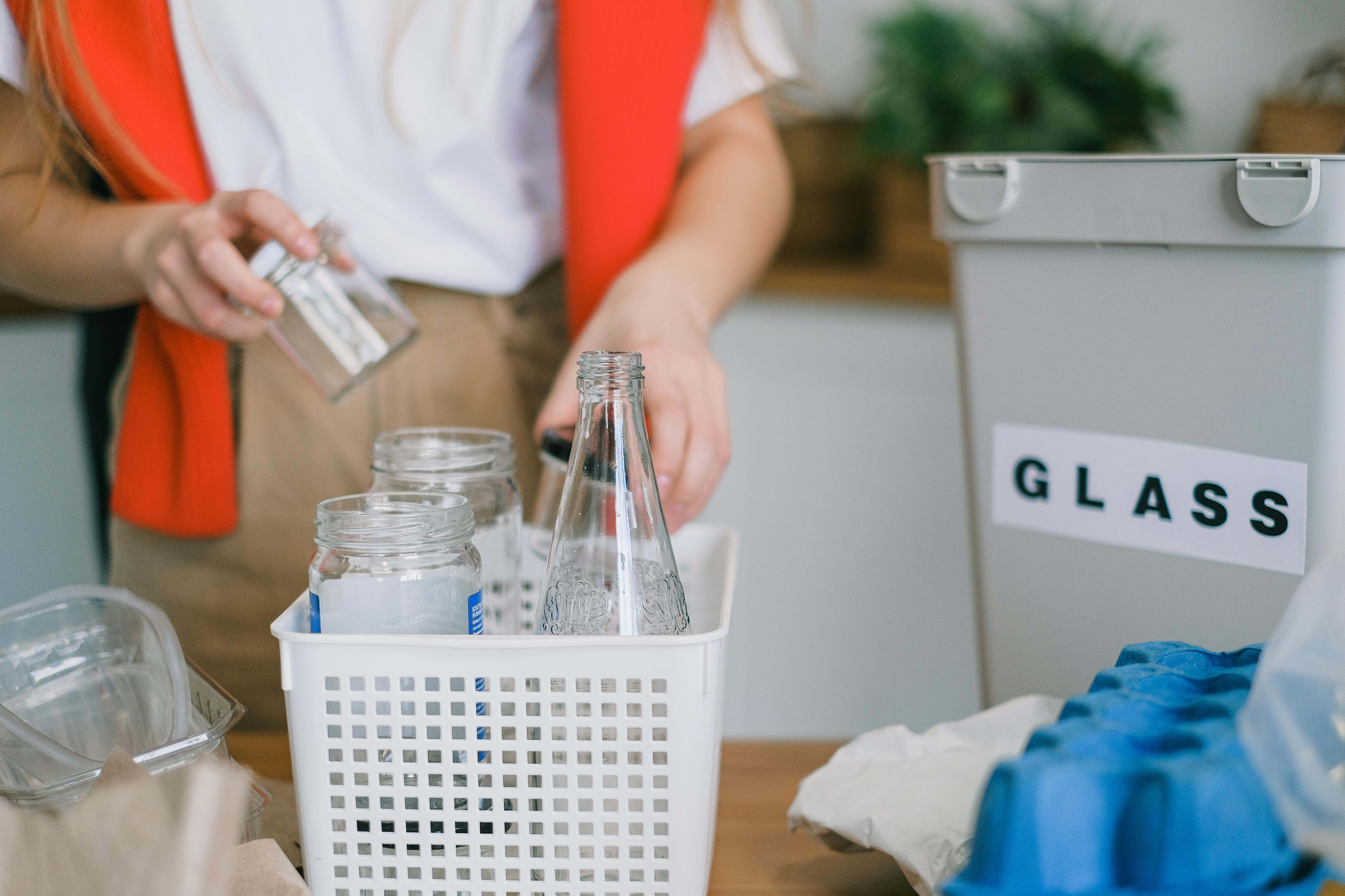 Woman sorting glass into recycling bins